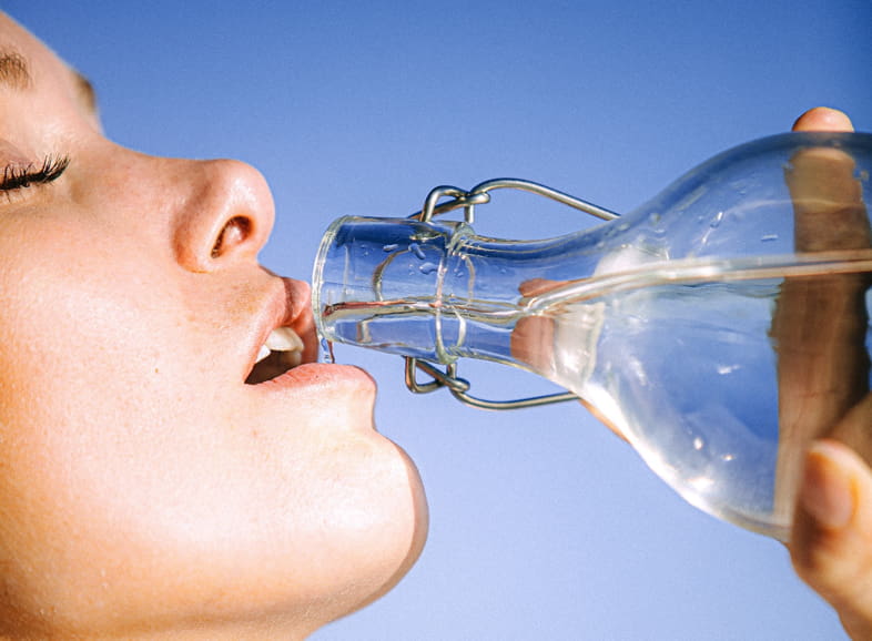 Mujer bebiendo agua para satisfacer la sensación de sed